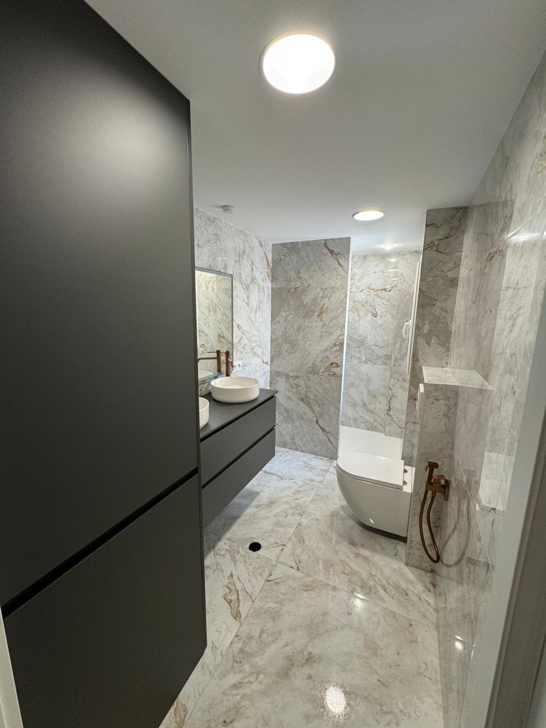 Baño en fase de acabados con revestimiento de mármol